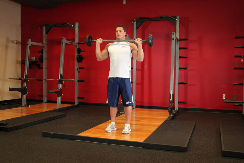 Demonstration of Standing Military Press exercise showing proper form and technique