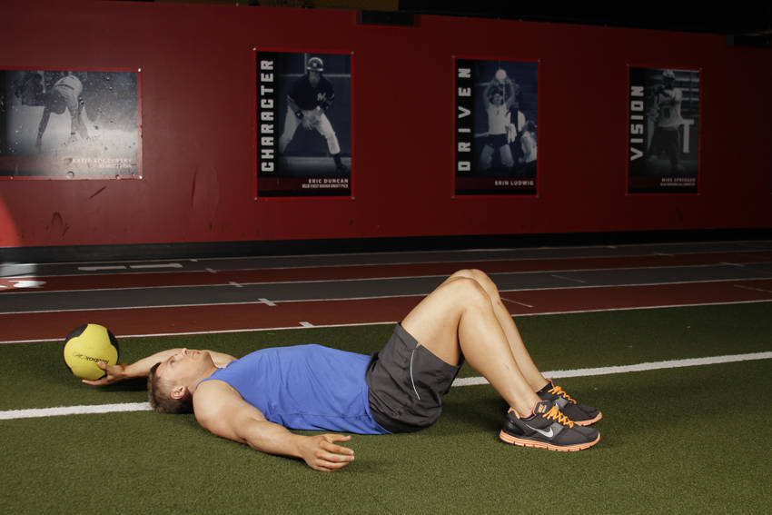 Demonstration of Supine One-Arm Overhead Throw exercise showing proper form and technique