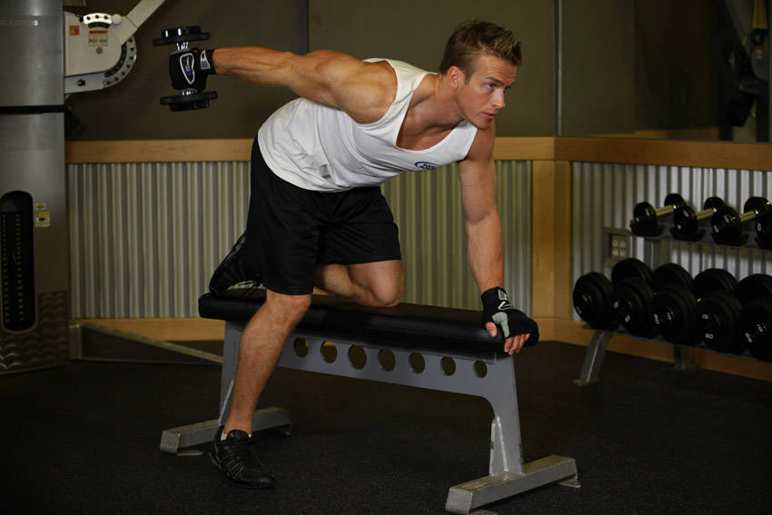Demonstration of Tricep Dumbbell Kickback exercise showing proper form and technique