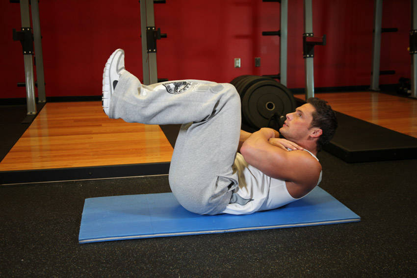 Demonstration of Tuck Crunch exercise showing proper form and technique