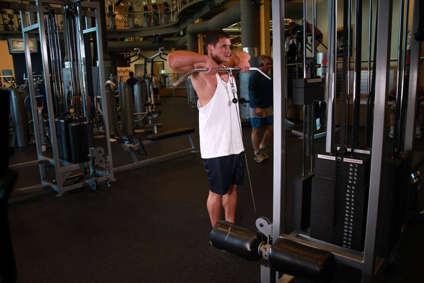 Demonstration of Upright Cable Row exercise showing proper form and technique
