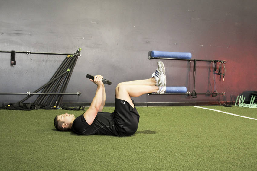 Demonstration of Weighted Crunches exercise showing proper form and technique