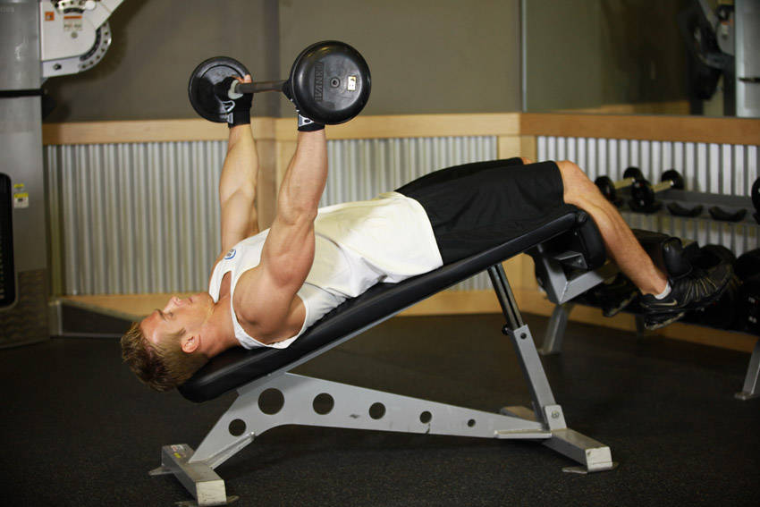 Demonstration of Wide-Grip Decline Barbell Pullover exercise showing proper form and technique