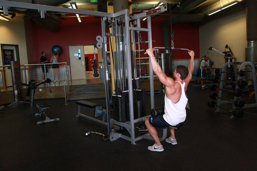 Demonstration of Wide-Grip Lat Pulldown exercise showing proper form and technique