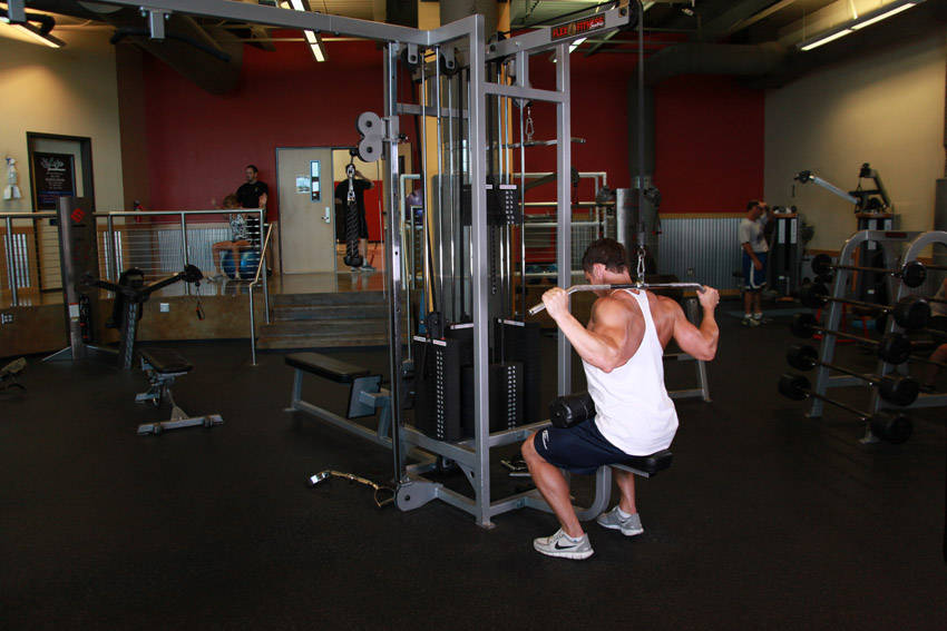 Demonstration of Wide-Grip Pulldown Behind The Neck exercise showing proper form and technique