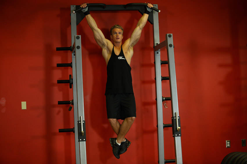 Demonstration of Wide-Grip Rear Pull-Up exercise showing proper form and technique